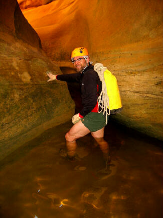 Hank Moon wading through clear and cold water.